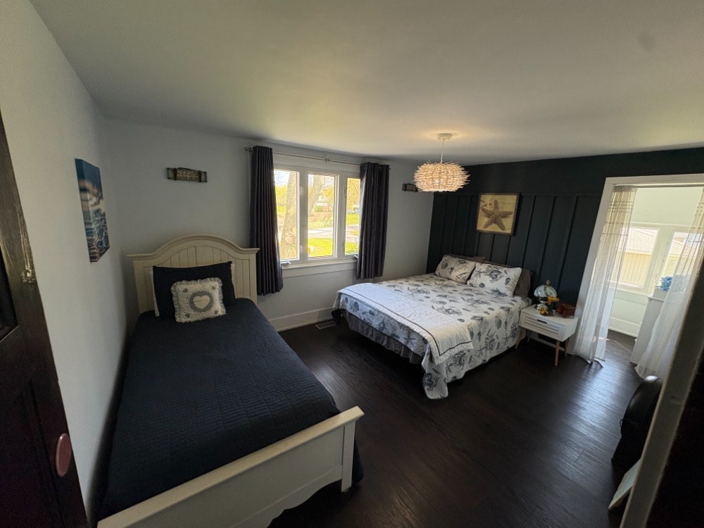 2nd floor bedroom with twin and queen beds and dark accent wall