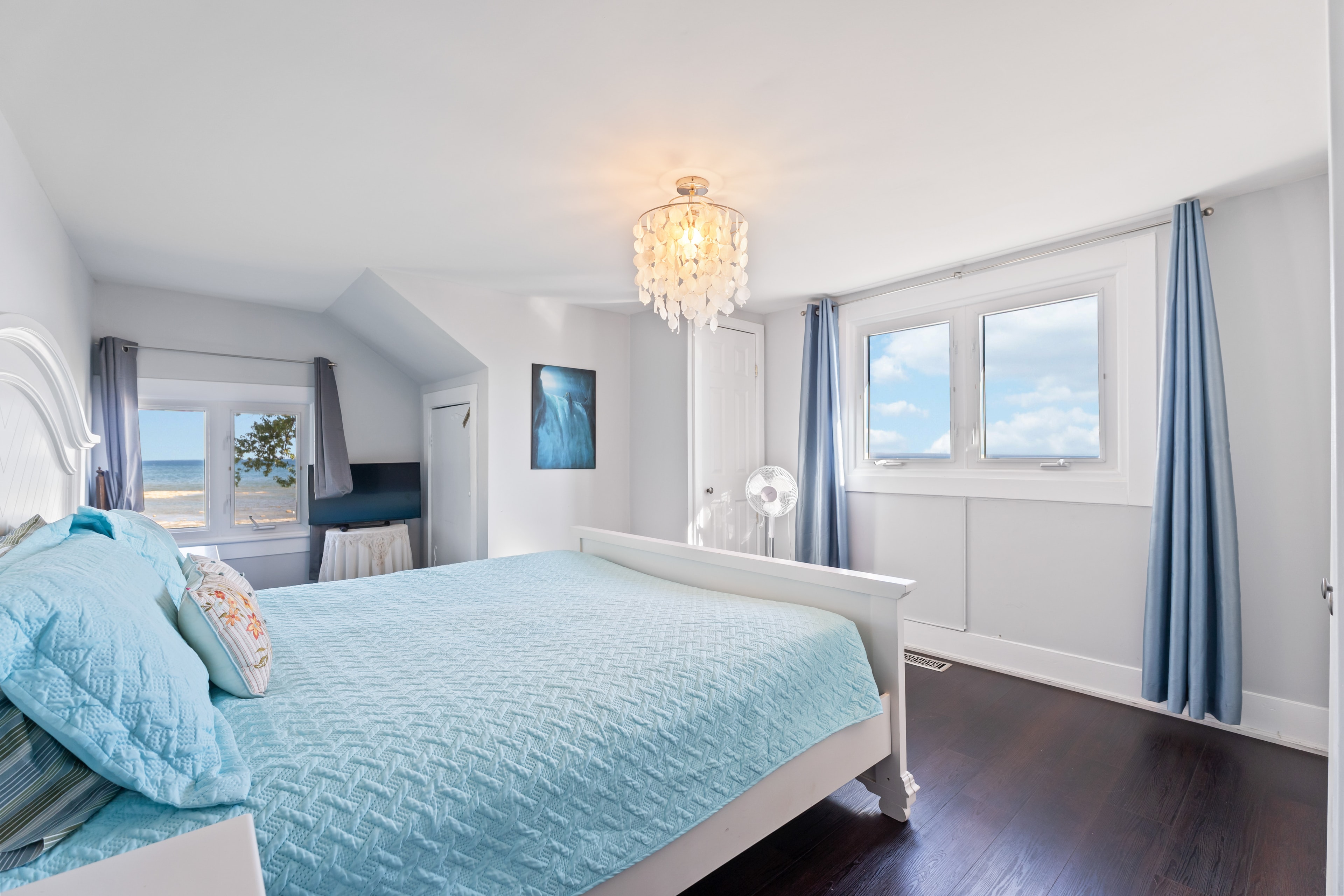 Primary bedroom with lake view and chandelier