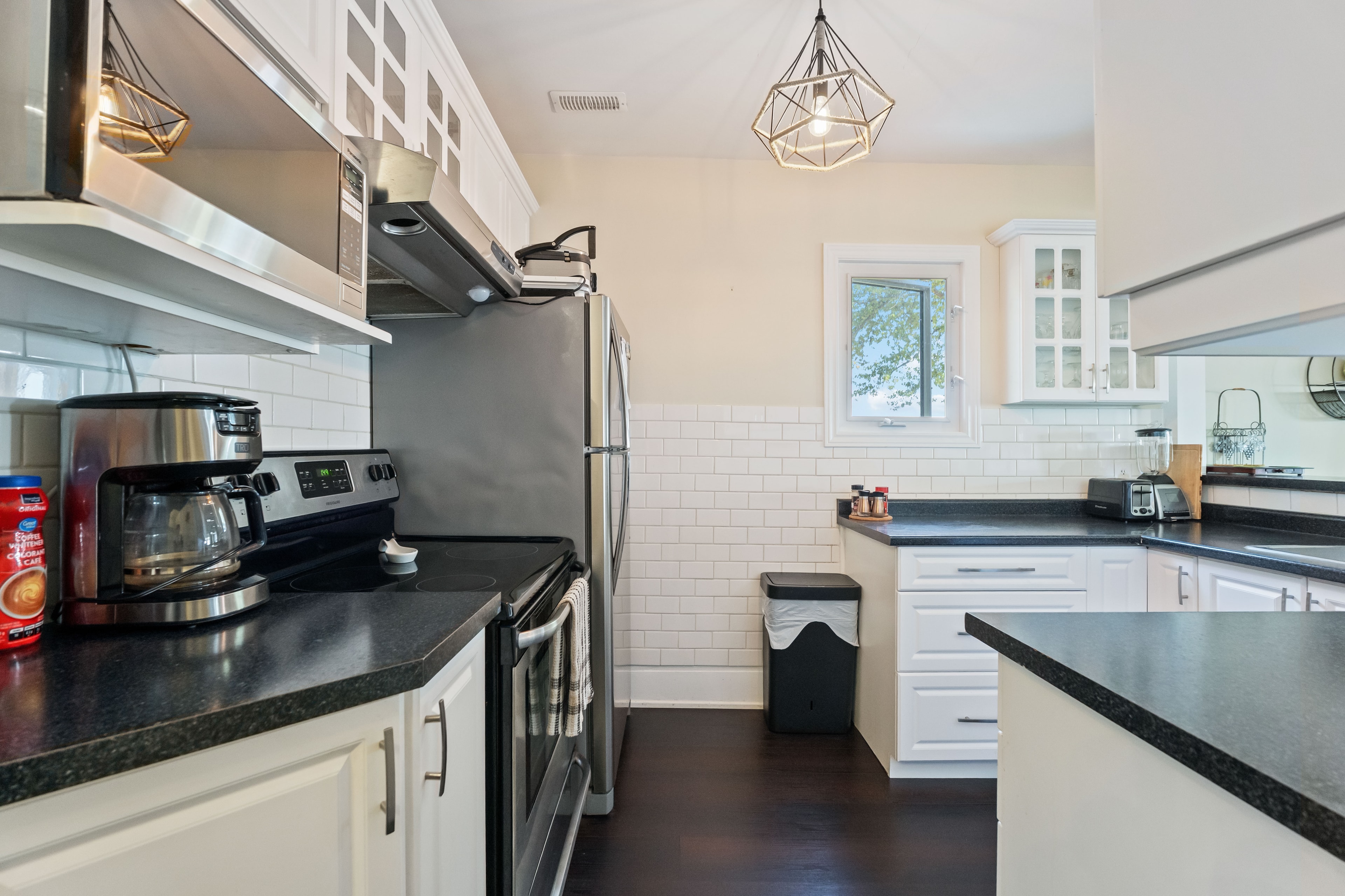 Kitchen with white cabinetry and black countertops